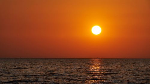 Scenic view of sea against orange sky