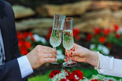 Cropped hand of groom toasting champagne flute to bride during wedding ceremony