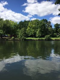 Scenic view of lake by trees against sky