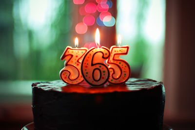 Close-up of lit candles on cake