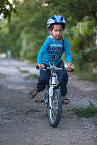 Boy riding bicycle on road