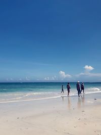 People walking on beach against sky