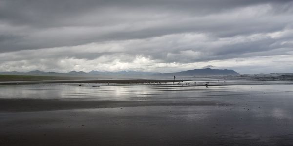 Scenic view of beach against cloudy sky