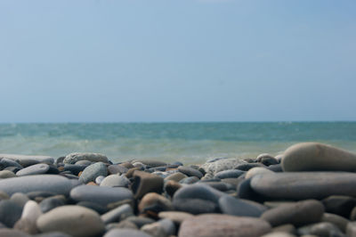 Stones on beach against sky