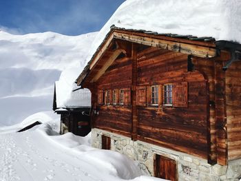 Built structure on snowcapped mountain against sky