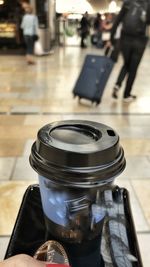 Close-up of hand holding camera on table