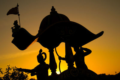 Low angle view of silhouette statue against sky during sunset