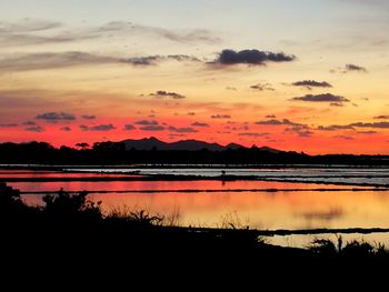 Scenic view of lake against orange sky