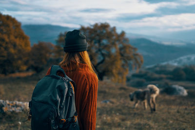 Rear view of woman standing against sky