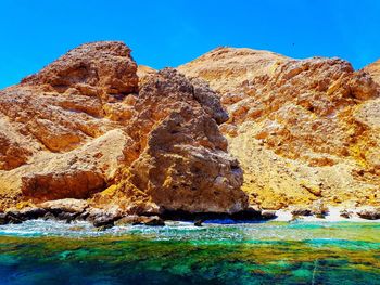 Rock formation in sea against sky