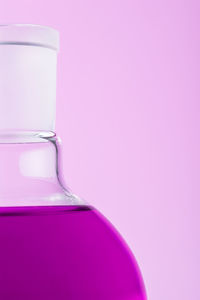 Close-up of flask against pink background