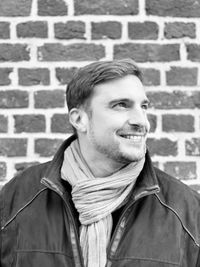 Portrait of smiling young man against wall