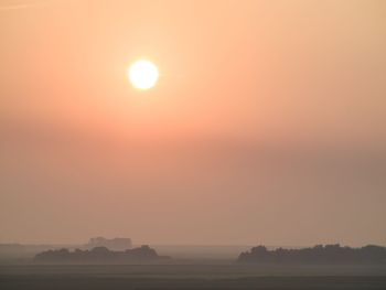 Scenic view of silhouette field against sky during sunset