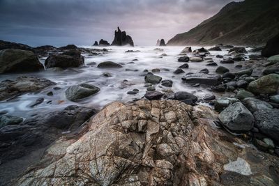 Rocks on beach during sunset