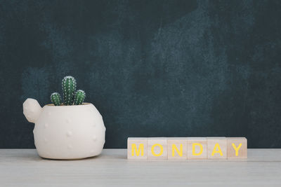 Potted plants on table against wall