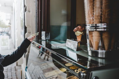 Cropped hand of person paying at ice cream store
