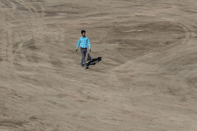 High angle view of man walking in desert