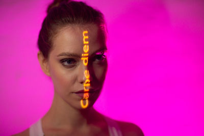 Portrait of woman against pink background