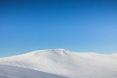 Scenic view of snowcapped mountains against clear blue sky