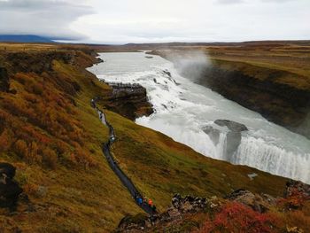 Scenic view of waterfall against sky in iceland.