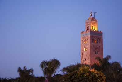 Low angle view of illuminated building against clear sky at dusk