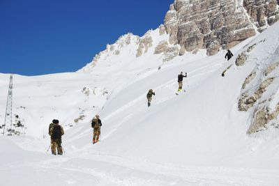 Tourists on snow covered mountain