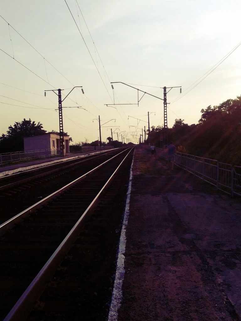 railroad track, power line, electricity pylon, rail transportation, power supply, electricity, transportation, cable, connection, the way forward, diminishing perspective, public transportation, sky, power cable, vanishing point, fuel and power generation, railroad station platform, railroad station, railway track, technology