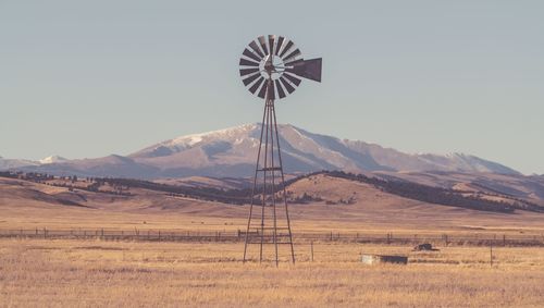 Windmill on field against clear sky