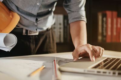 Midsection of man using laptop on table