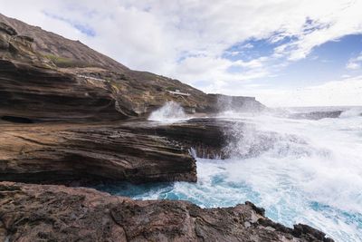 Scenic view of waterfall against sky