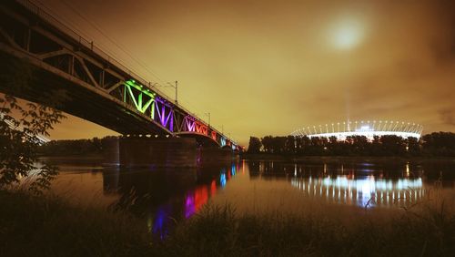 View of illuminated bridge over river at night