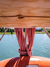 Close-up of rope tied to boat moored in lake
