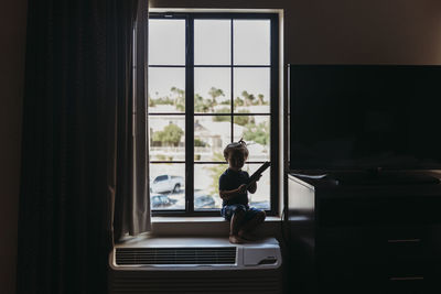 Woman sitting in glass window at home