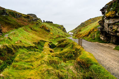 Road amidst green mountains against sky