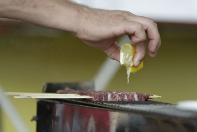 Cropped image of person hand on barbecue grill