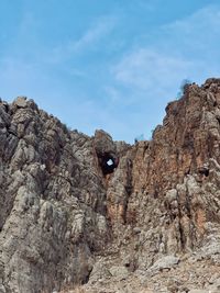 Low angle view of rock formations on mountain against sky