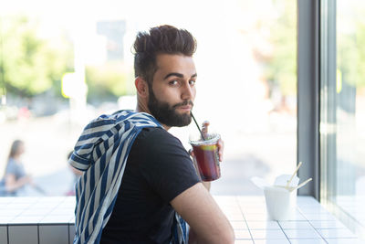 Young man drinking coffee in restaurant