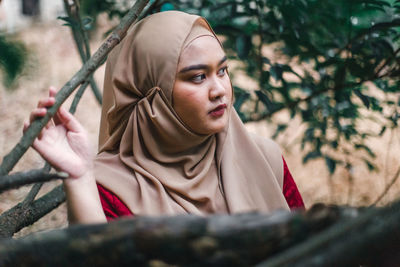 Thoughtful young woman wearing hijab looking away