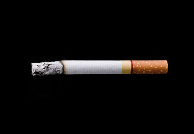 Close-up of cigarette over black background