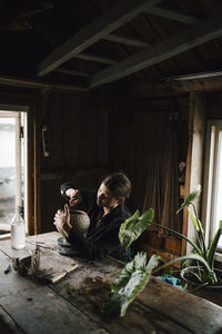 Female potter making vase in workshop