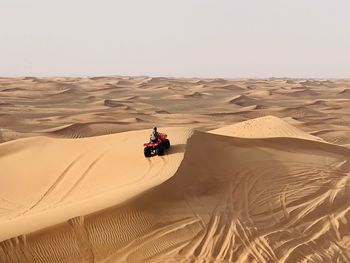 People riding motorcycle in desert
