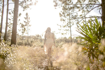 Rear view of woman walking on field