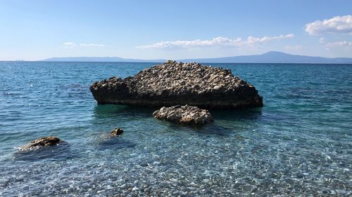 Rocks in sea against sky