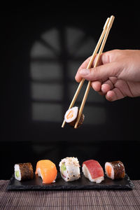 Midsection of woman holding sushi on table