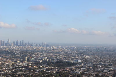 Aerial view of buildings in city against sky