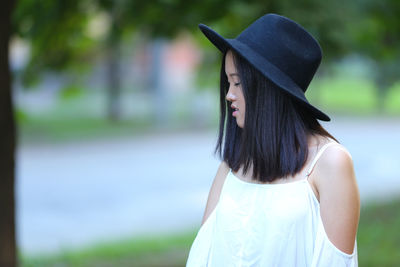 Close-up of woman wearing hat standing on land