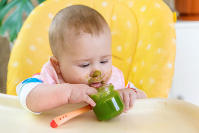 Close-up of cute baby boy eating food at home