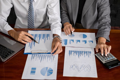 Midsection of business colleagues working at table