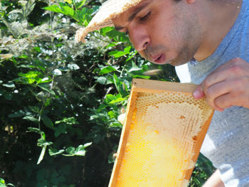 Side view of man holding plant