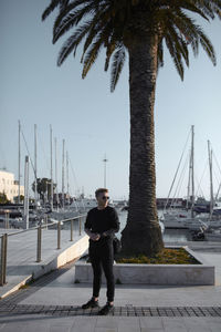 Man standing at harbor against sky